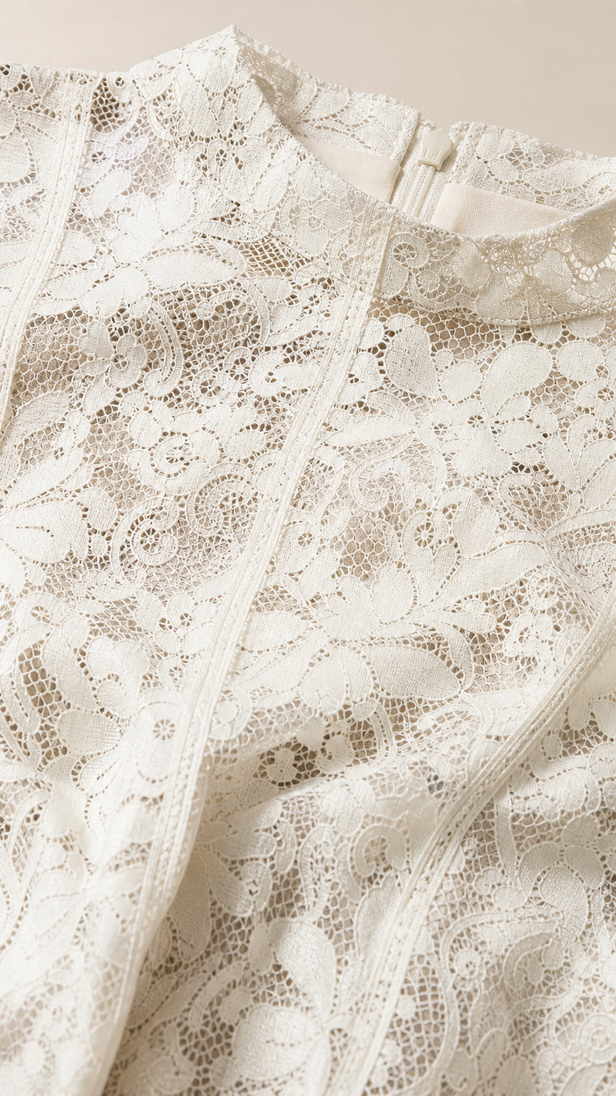 Close-up detail of white floral lace fabric and mock neckline