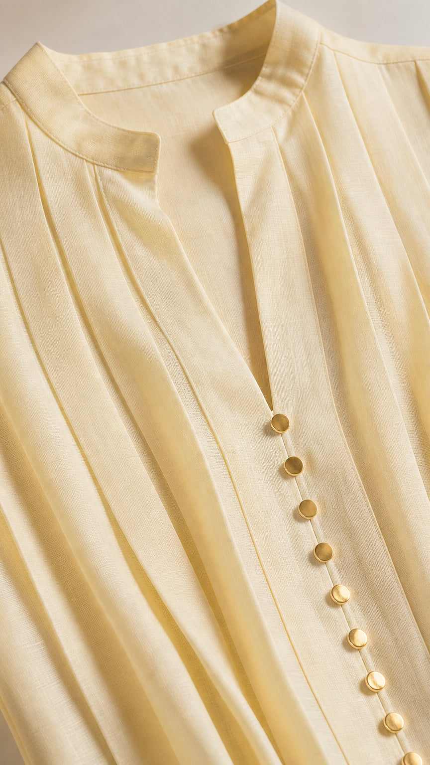 Close-up of Mandarin collar and metallic buttons on yellow top