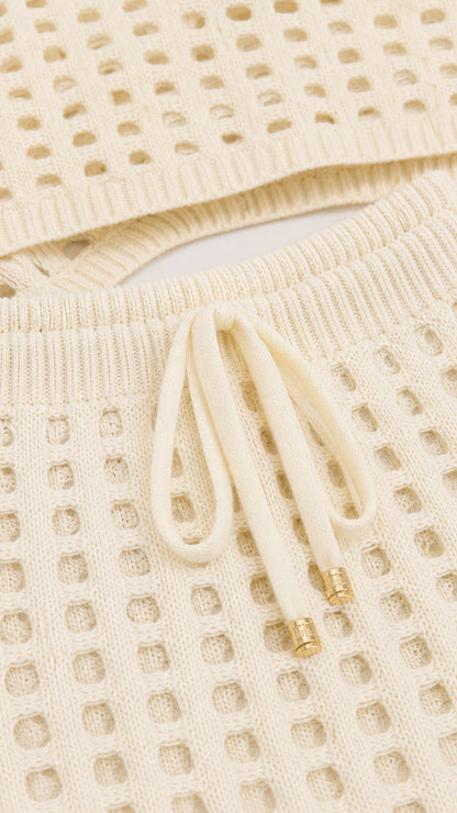 Close-up detail of off-white knit texture and drawstring waist
