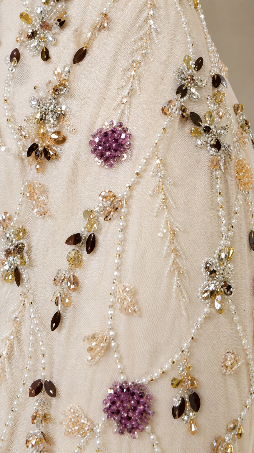 Close-up detail shot of intricate beadwork and floral embroidery on dress