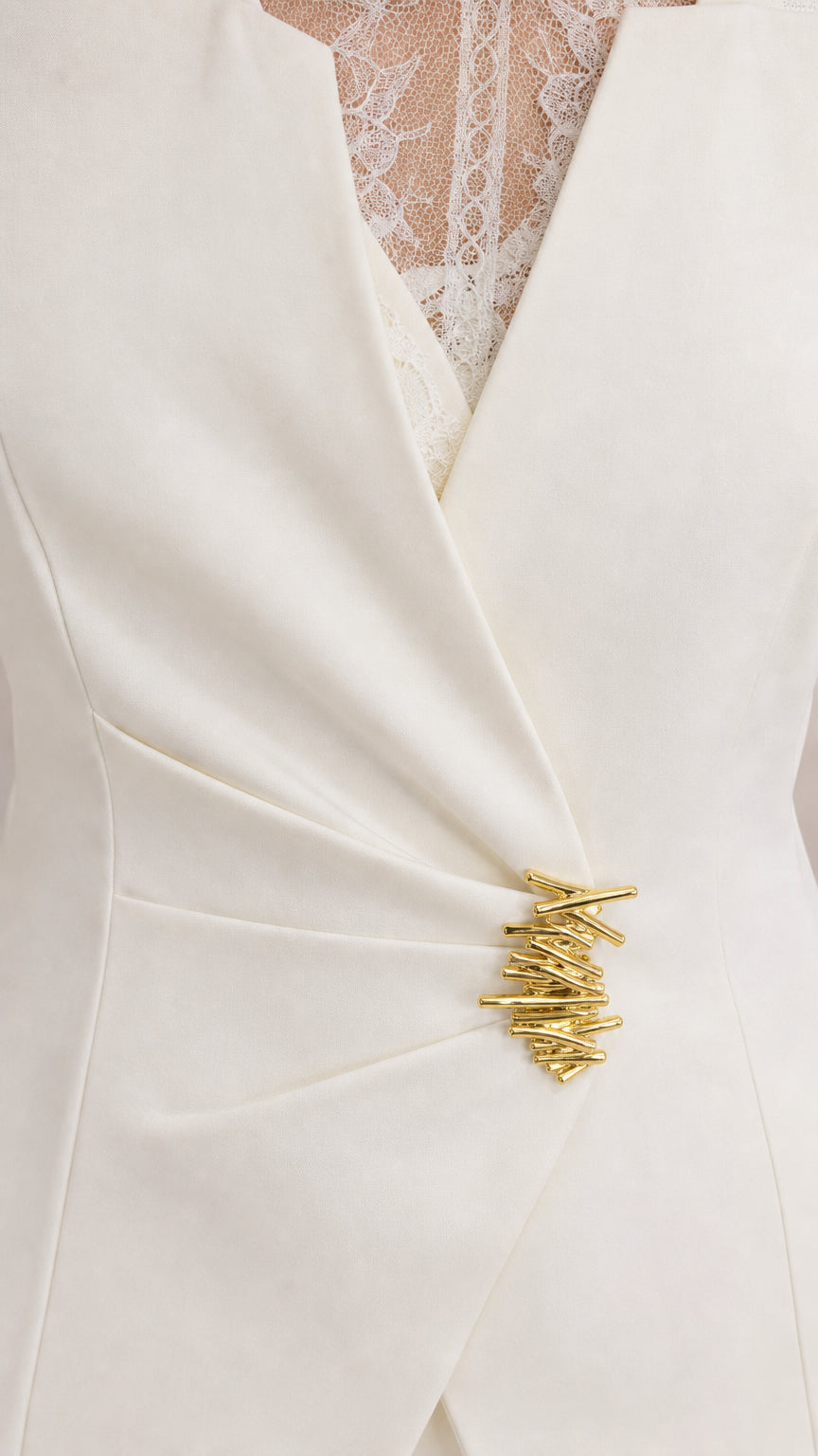Close-up detail of V-neckline lace insert and ruched waist with gold metallic hardware