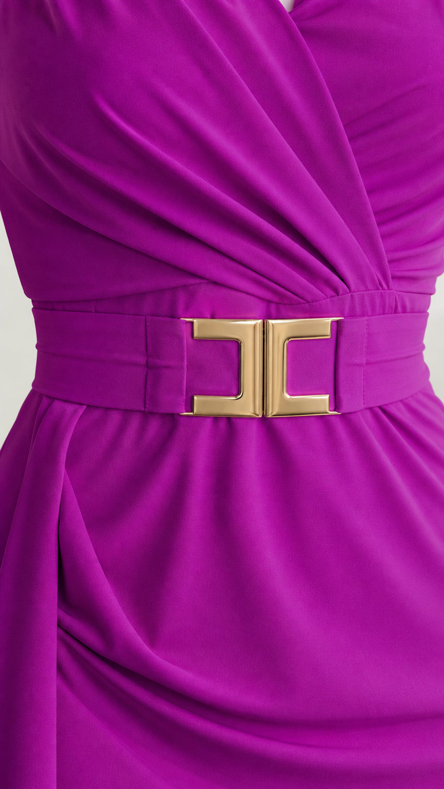 Close-up detail of fuchsia dress wrap bodice and gold waist buckle