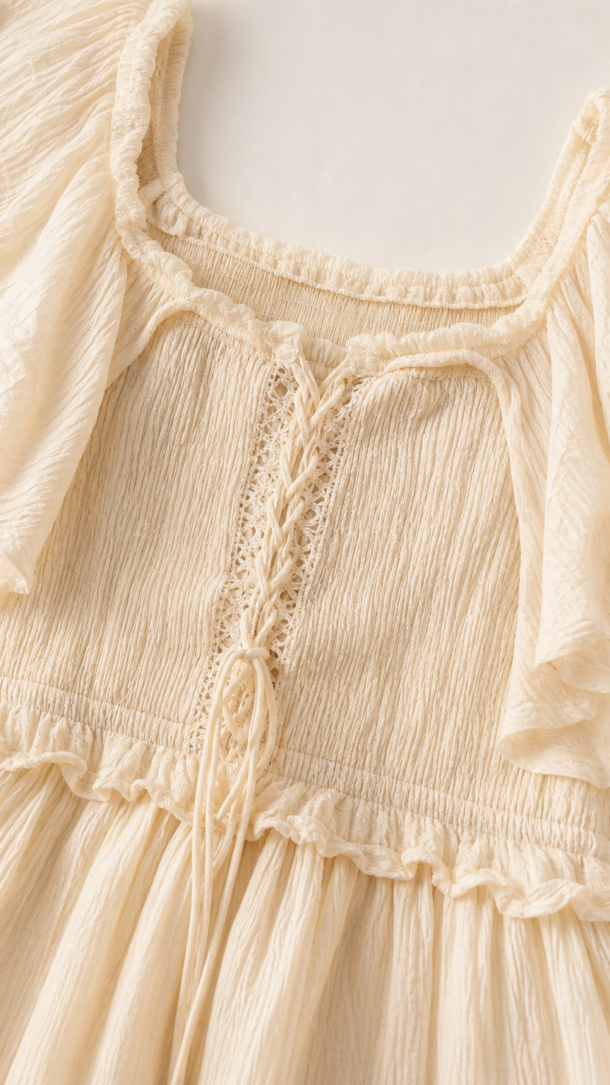 Close-up detail of lace-up bodice and textured fabric