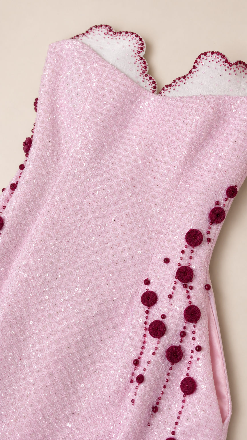 Close-up of pink dress scalloped neckline and beadwork