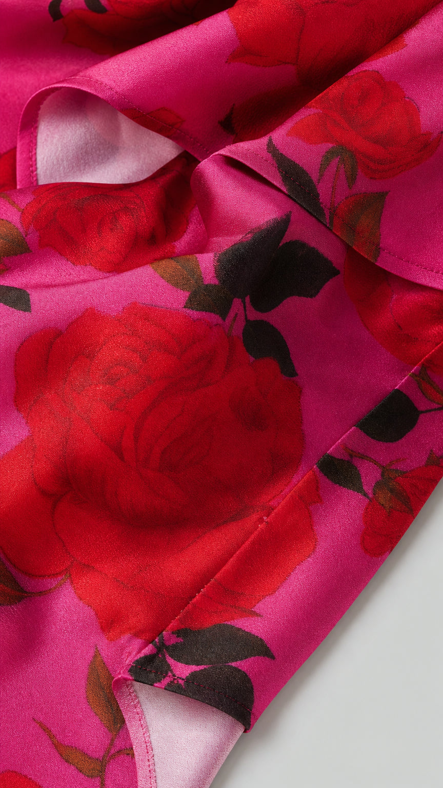 Close-up fabric detail of vibrant rose pattern on pink background