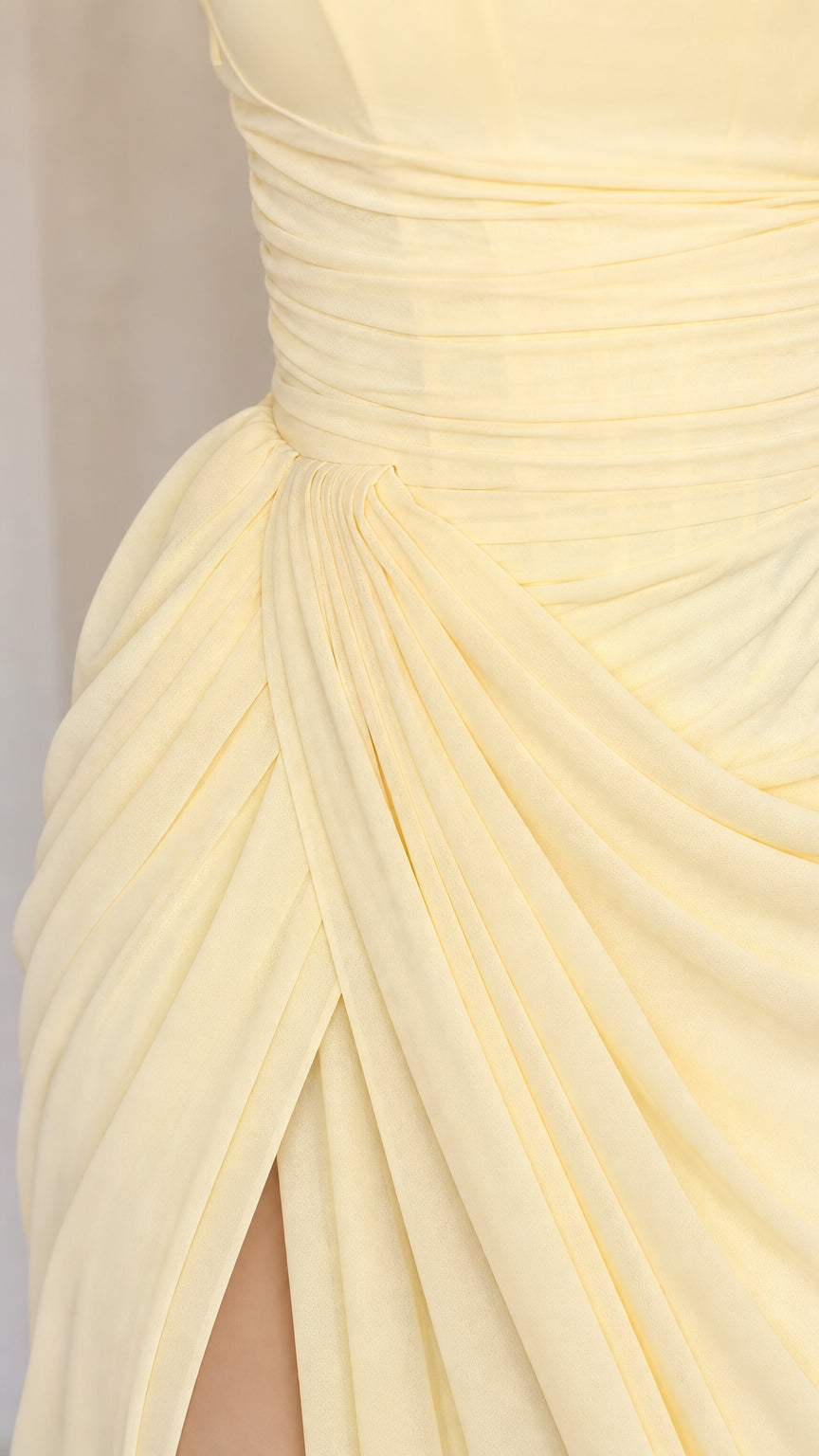 Close-up detail of ruching and high slit on yellow dress