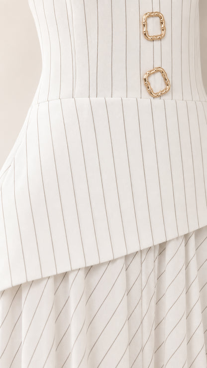 Close-up of metallic hardware buttons and asymmetric peplum hem