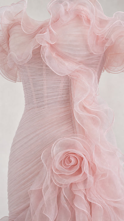 Close-up detail of structured bodice, ruffles, and rosette applique on pink gown