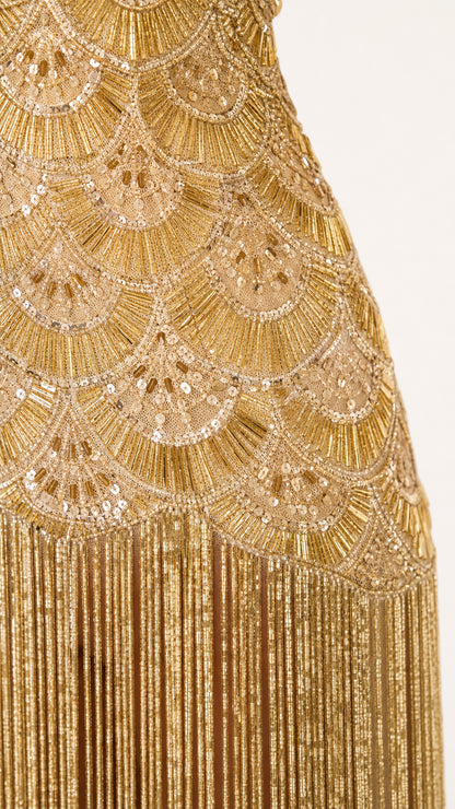 Close-up detail of gold beadwork and fringe
