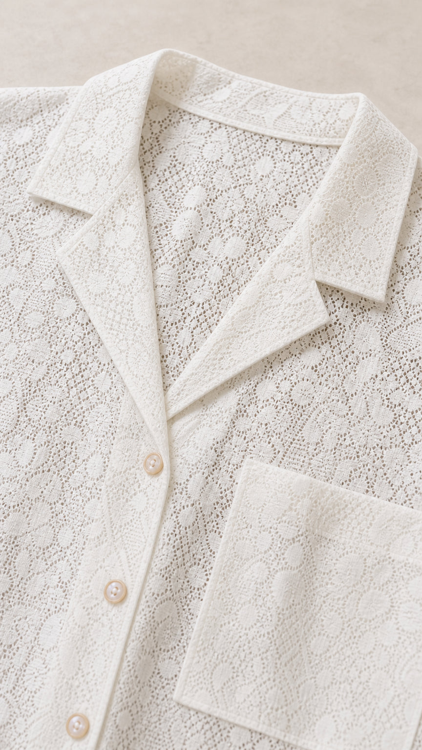Close-up detail of white lace fabric, lapel collar, and buttons