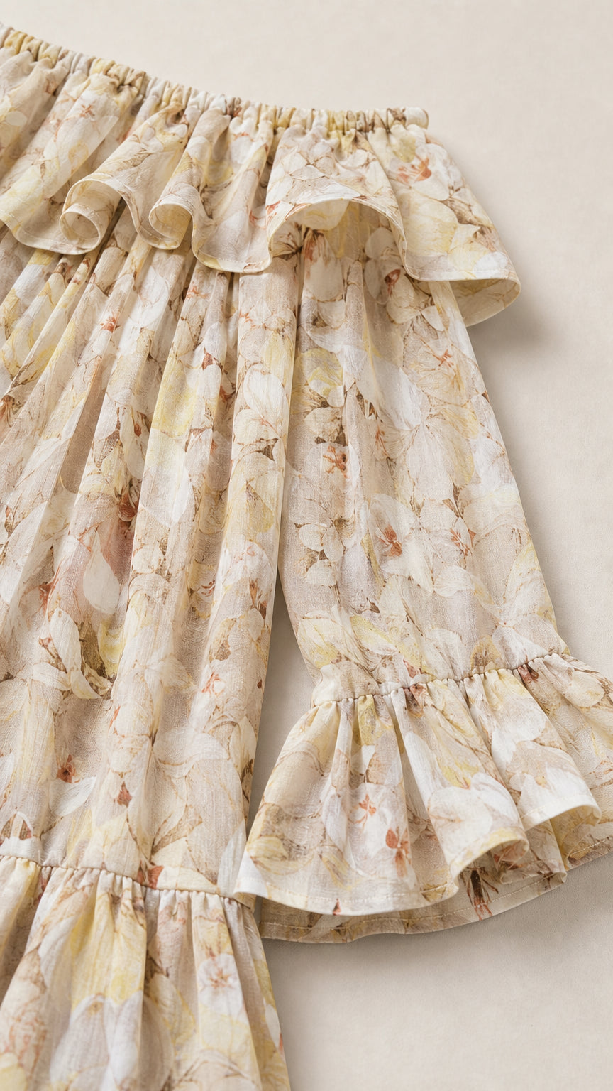 Close-up detail of fabric, ruffles, and sleeves on beige dress