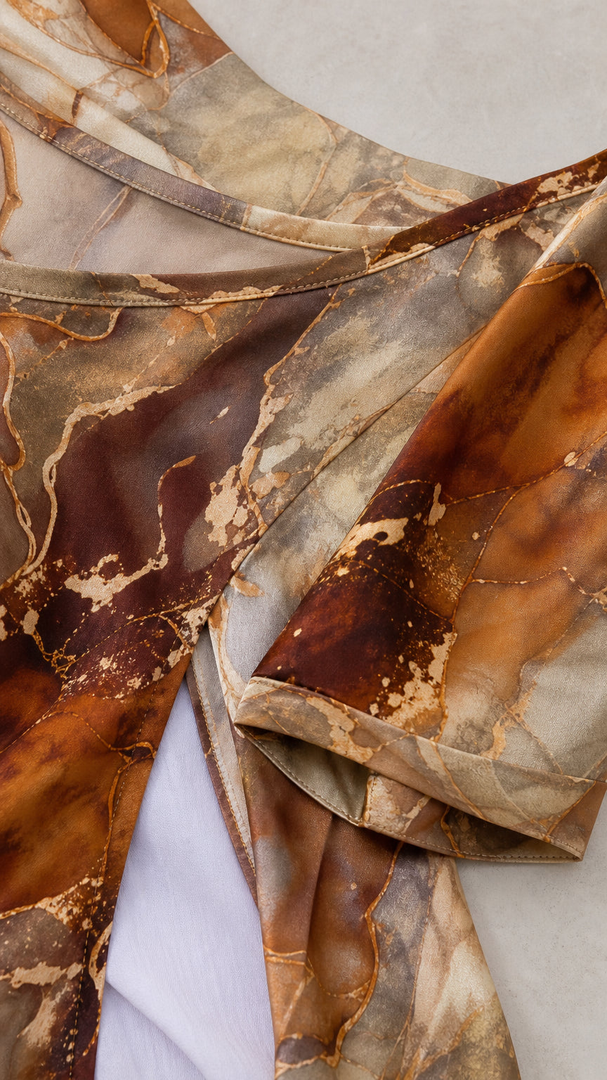 Close-up fabric and neckline detail of brown marble print tunic