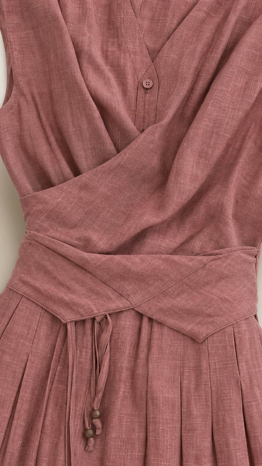 Close-up detail of crossover bodice, waist pleating, and button closure in Dusty Rose