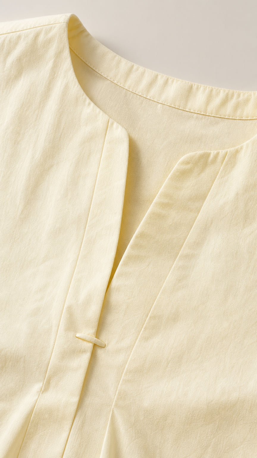Close-up detail of yellow dress neckline and front closure