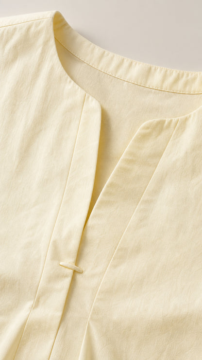 Close-up detail of yellow dress neckline and front closure