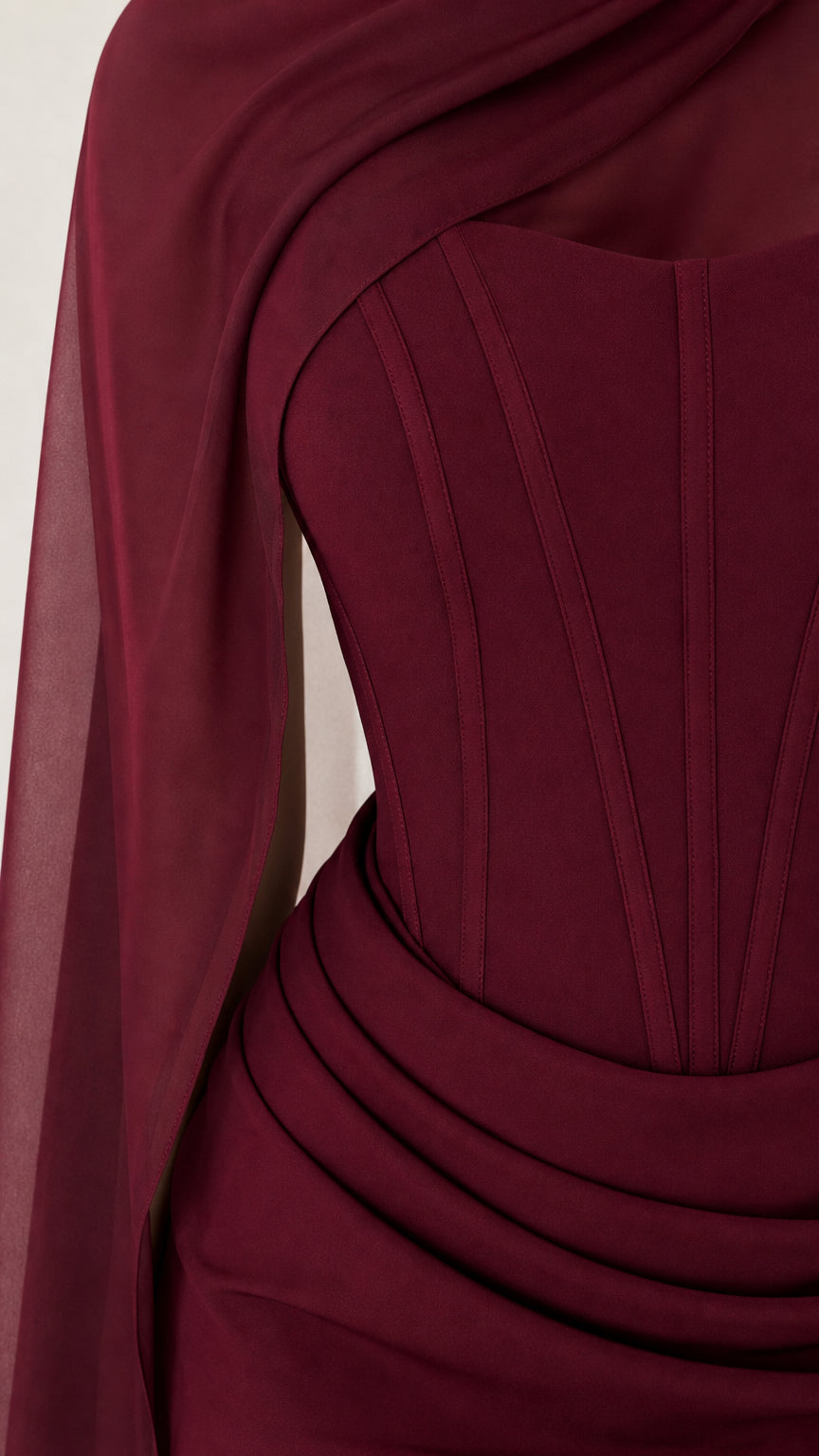 Close-up of structured boned corset and draped waistline on burgundy gown