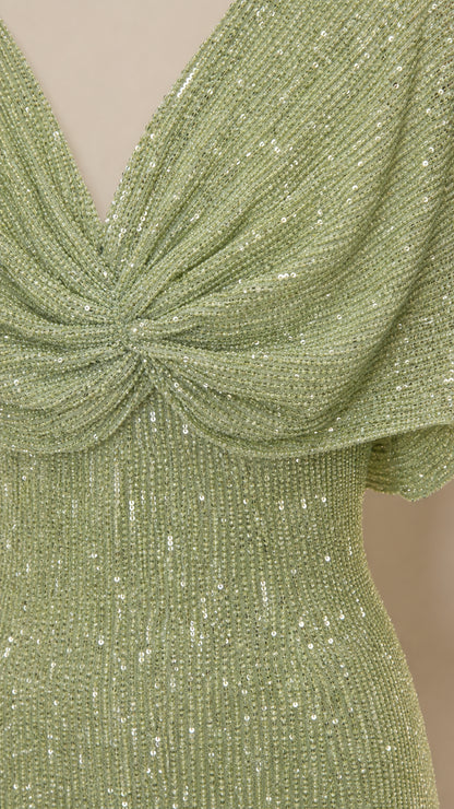 Close-up detail of V-neckline and sequin texture on sage green dress