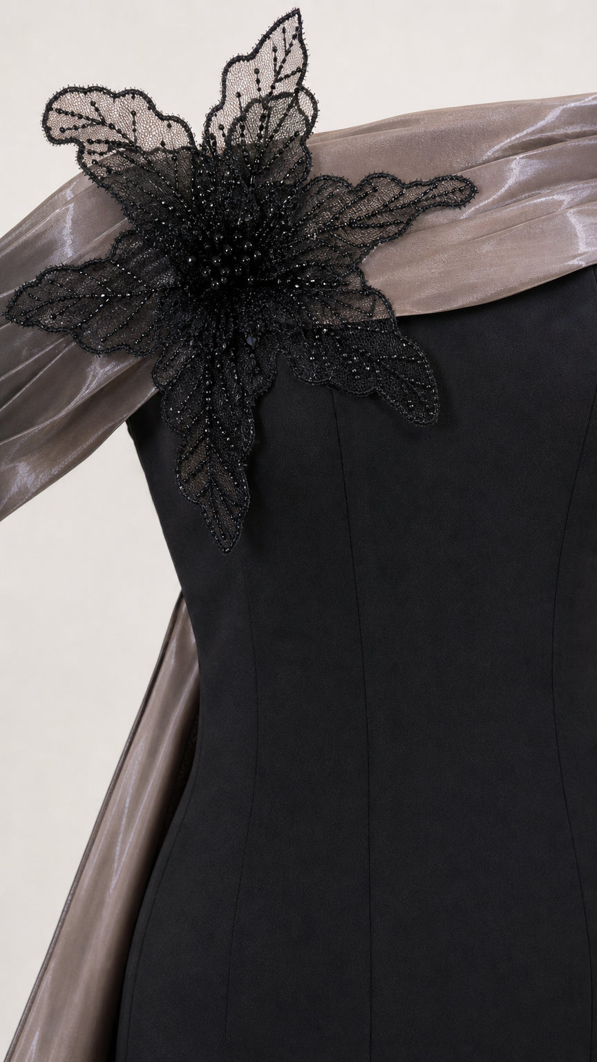 Close-up of the beaded black floral shoulder appliqué and metallic collar