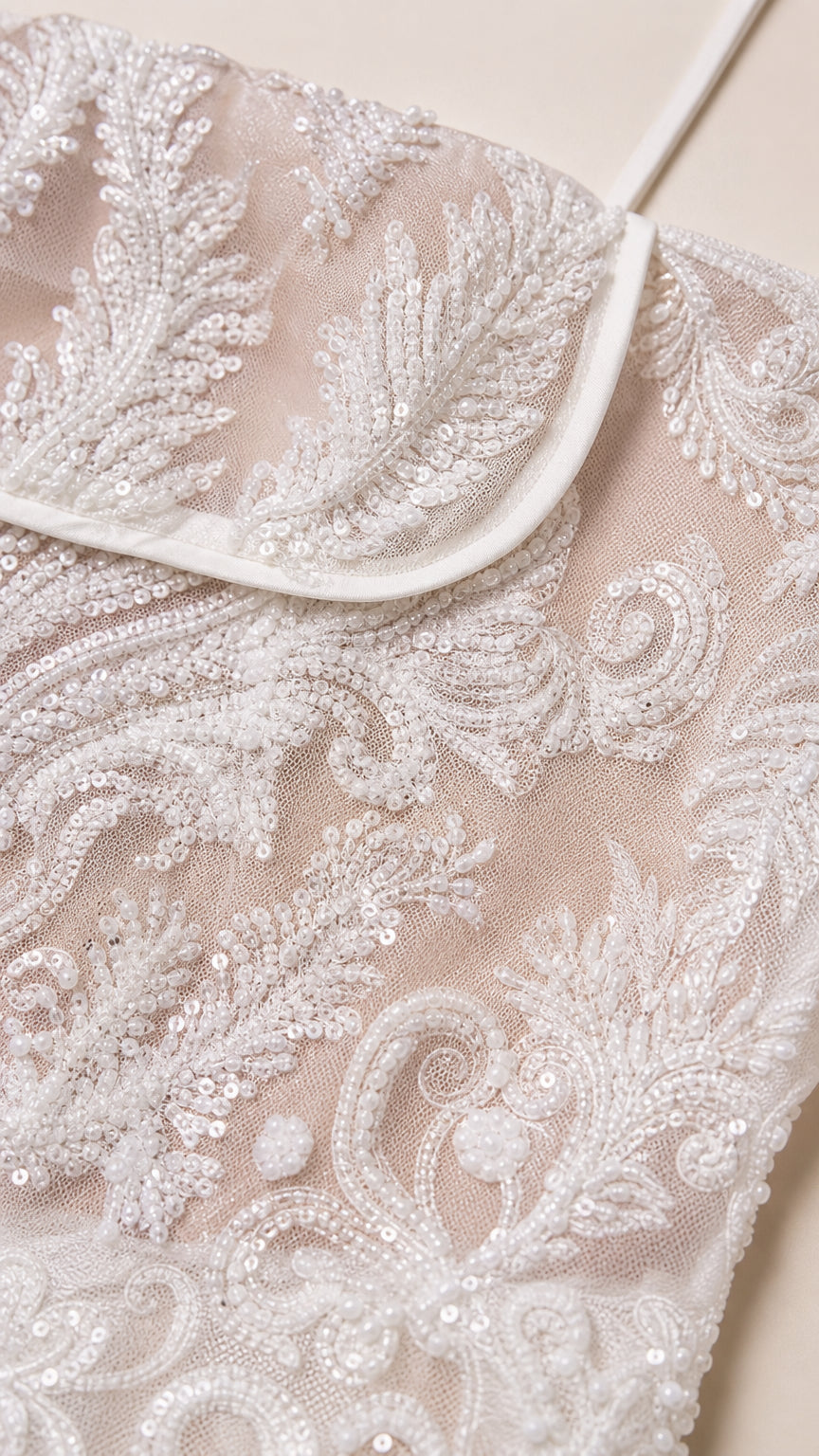 Close up detail of white embroidery and sequin pattern