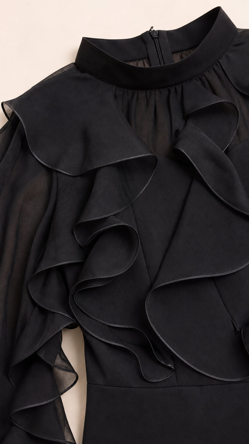 Close-up detail of mock neck and layered ruffles on black dress