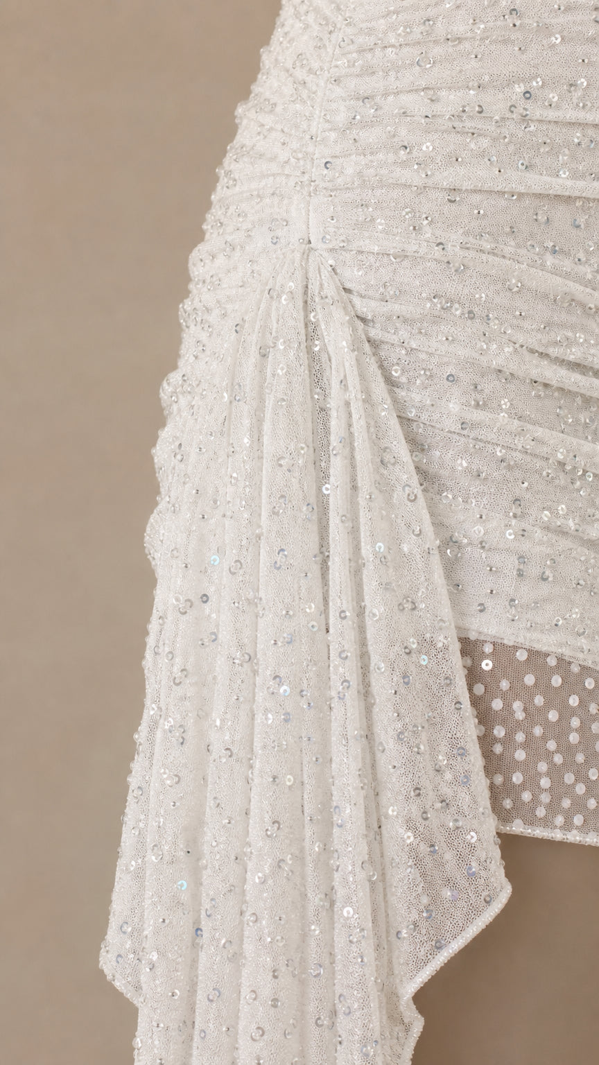 Close-up detail of white glitter mesh fabric and side drape overlay