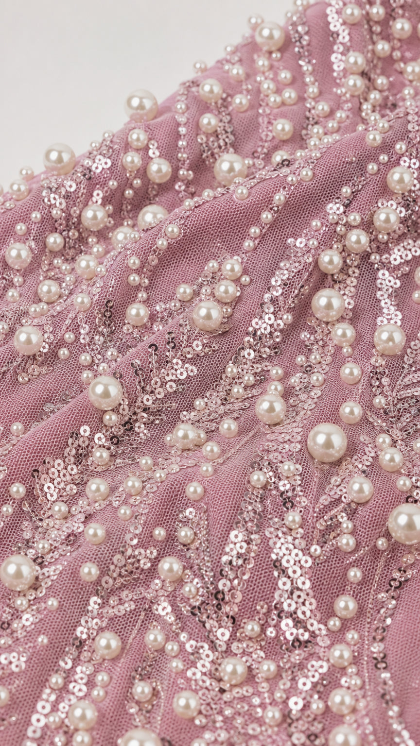 Close-up of pearl and sequin embellishments on mesh fabric