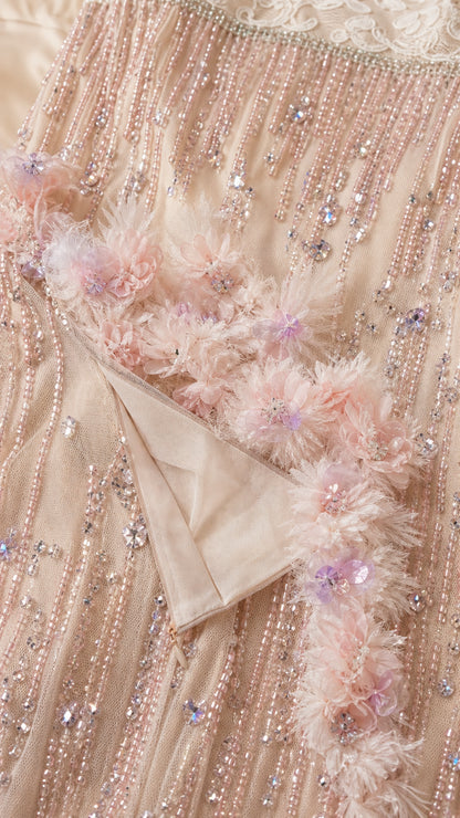 Close-up detail of hem, beading, and 3D floral appliques