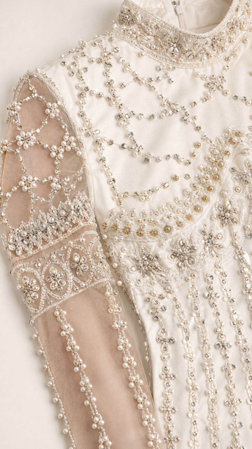 Close-up of intricate crystal and pearl beadwork on sheer sleeve