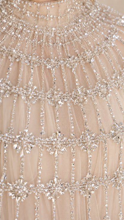 Close-up detail of intricate crystal beadwork on high neck tulle cape gown
