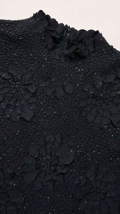 Close-up detail of black textured floral bodice and neckline