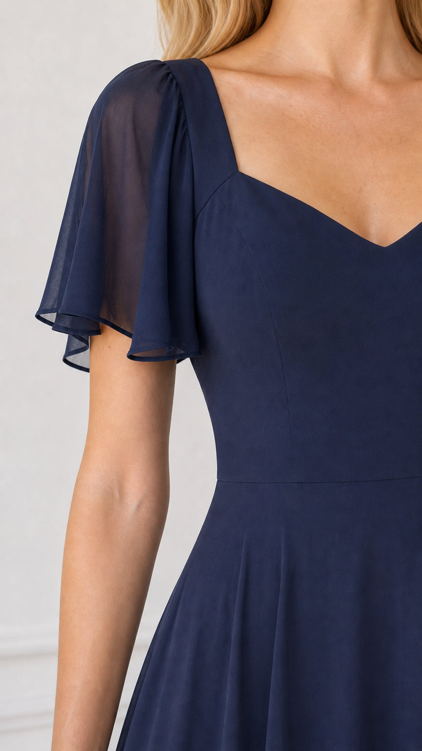 Close-up detail of sweetheart neckline and sheer flutter sleeve
