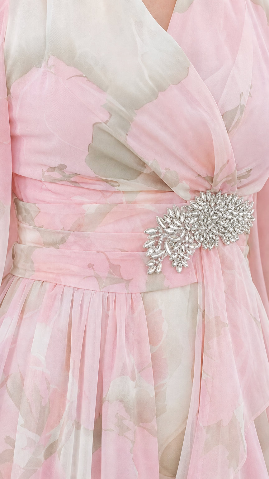 Close-up detail of pleated bodice and rhinestone crystal brooch on blush pink chiffon dress