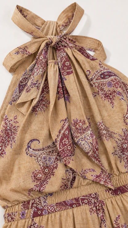 Close-up detail of the halter neckline, self-tie bow, and fabric texture