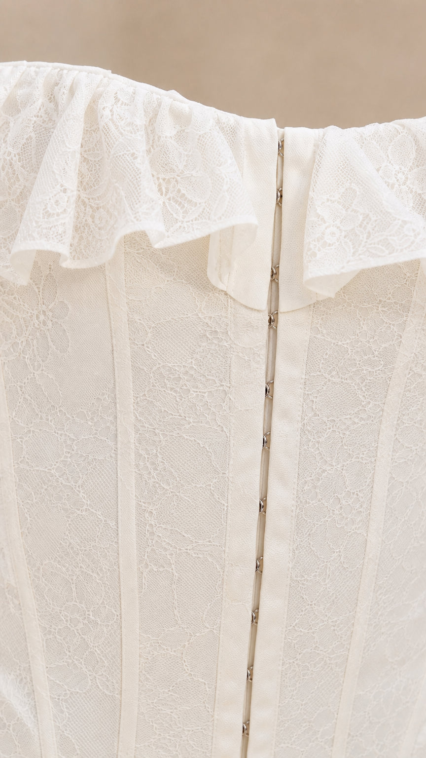 Close-up detail of white lace ruffles and front closure on corset top
