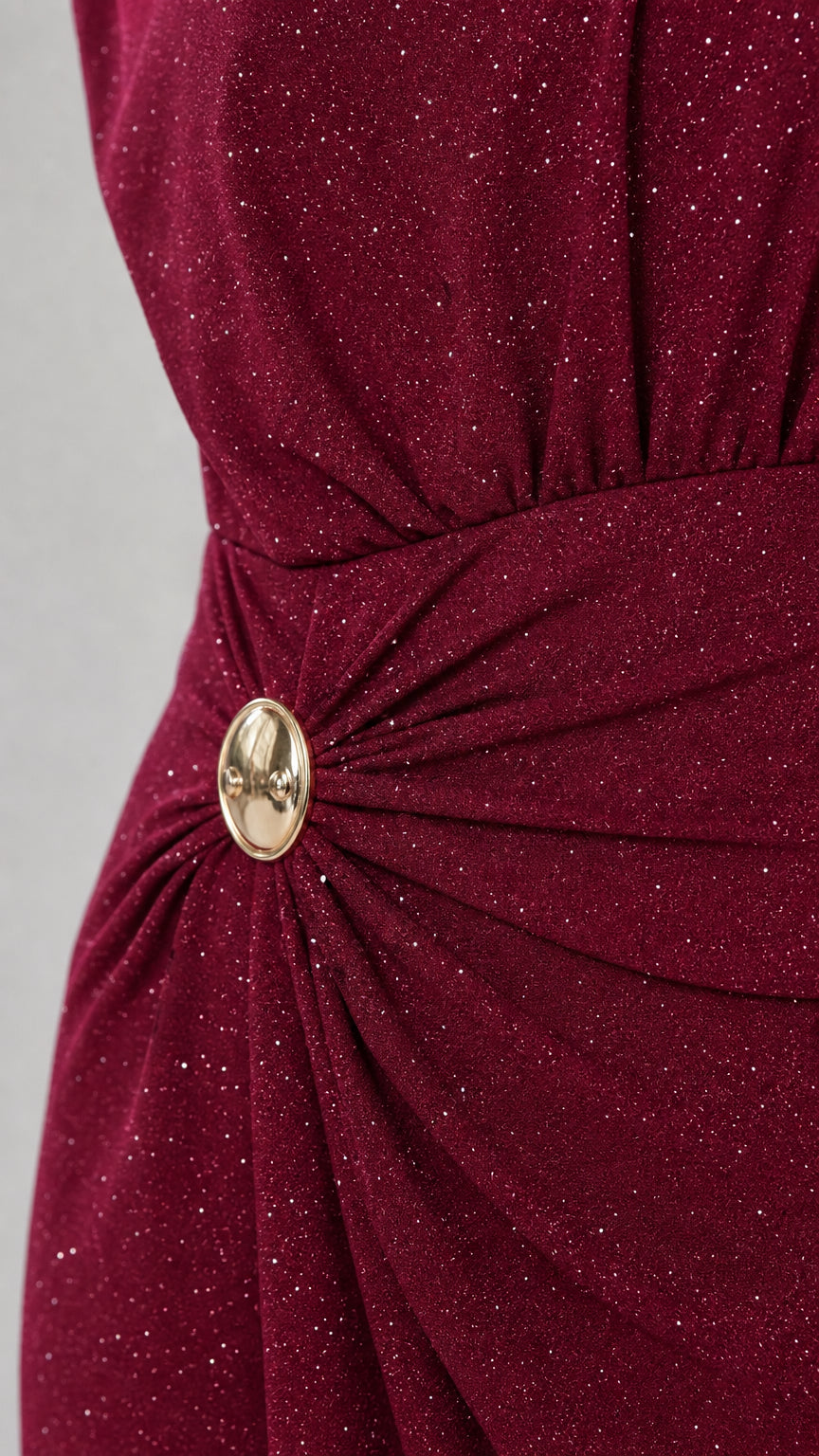 Close-up detail of Wine Red glitter knit fabric with side gathering and gold oval brooch accent