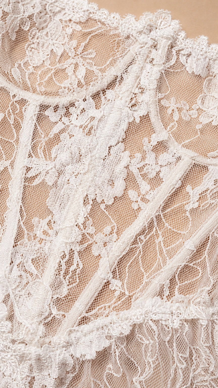 Close-up detail of white floral lace pattern and structured bodice