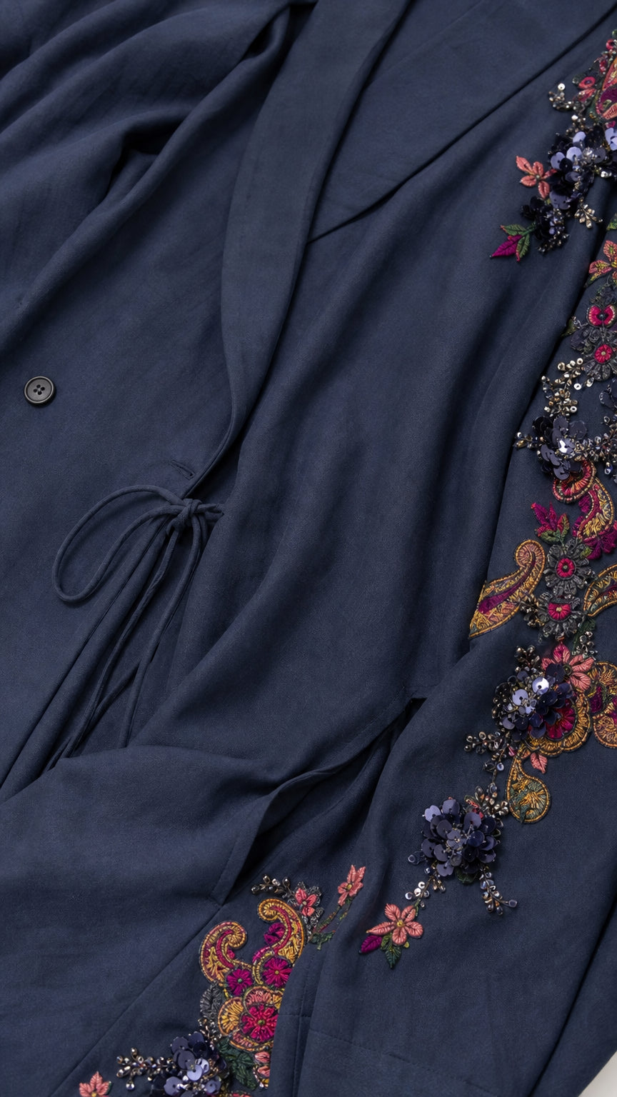 Close-up detail of navy fabric, drawstring waist, and floral embroidery