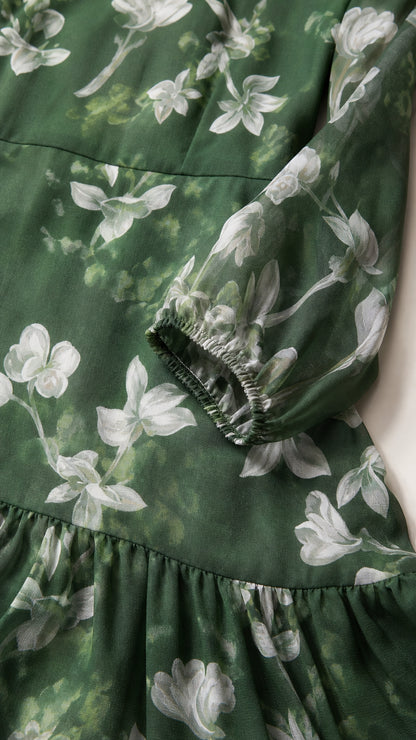 Close-up of fabric pattern and sleeve cuff on green floral dress