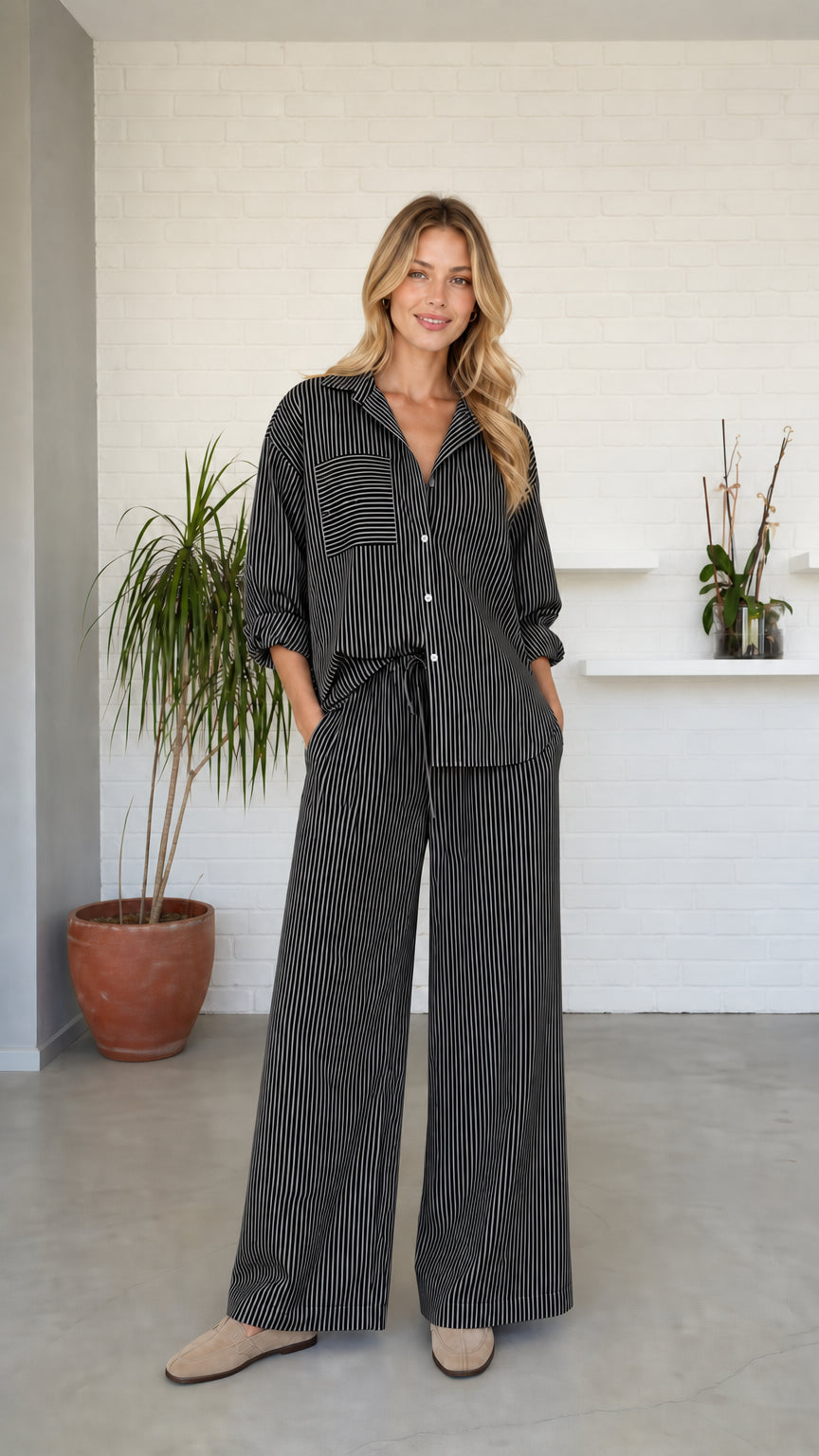 Woman wearing black striped button-down shirt and wide-leg pants