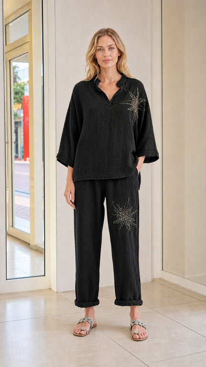 Front view of model wearing black embroidered two-piece pant set