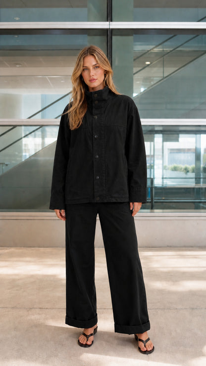 Woman wearing black two-piece stand-collar jacket and wide-leg pants set