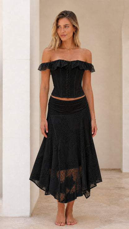 Woman wearing black off-shoulder lace corset top and midi skirt set