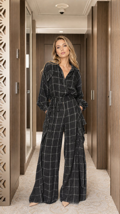 Full view of woman wearing black plaid long sleeve jumpsuit
