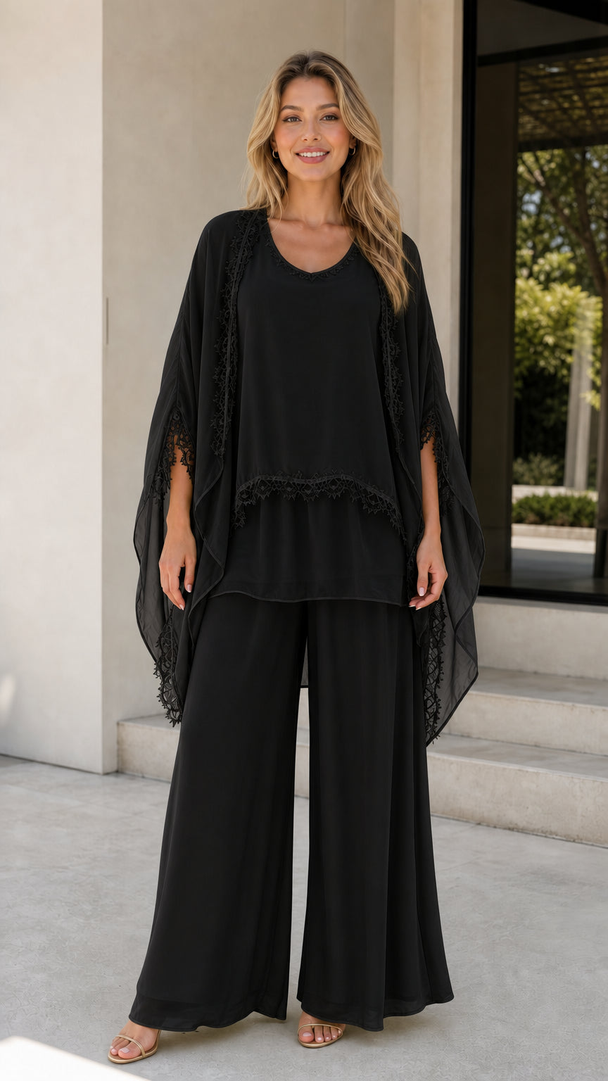 Model wearing black chiffon 3-piece pants set with cape