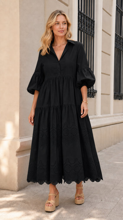 Front view of woman wearing black collared tiered midi dress