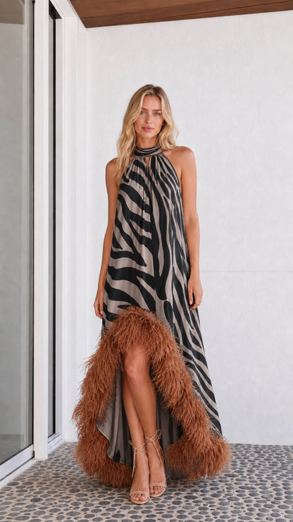 Model wearing black and white zebra print maxi dress with feather hem
