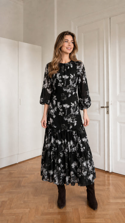 Woman wearing black floral print long sleeve tiered midi dress