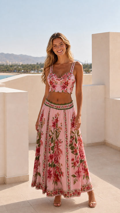 Model wearing pink floral two-piece crop top and maxi skirt set