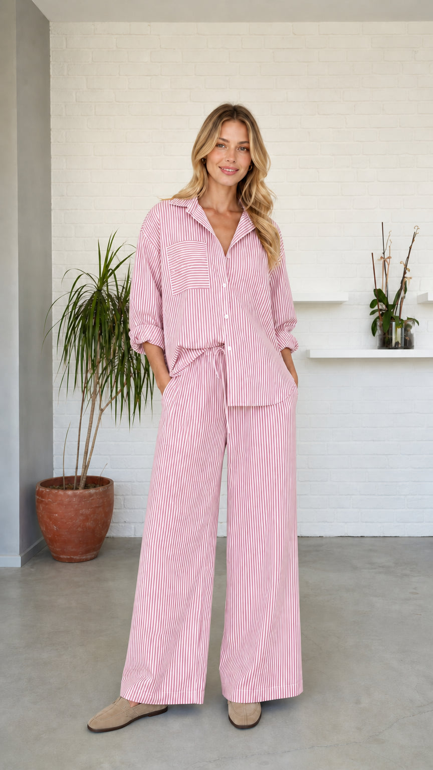 Woman wearing pink striped button-down shirt and wide-leg pants