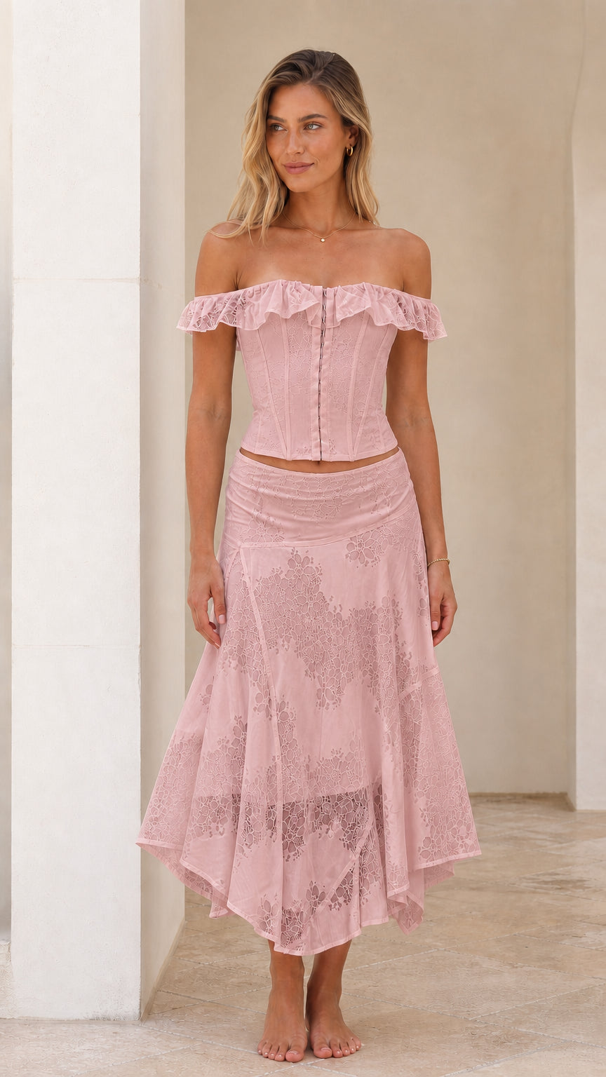 Woman wearing pink off-shoulder lace corset top and midi skirt set